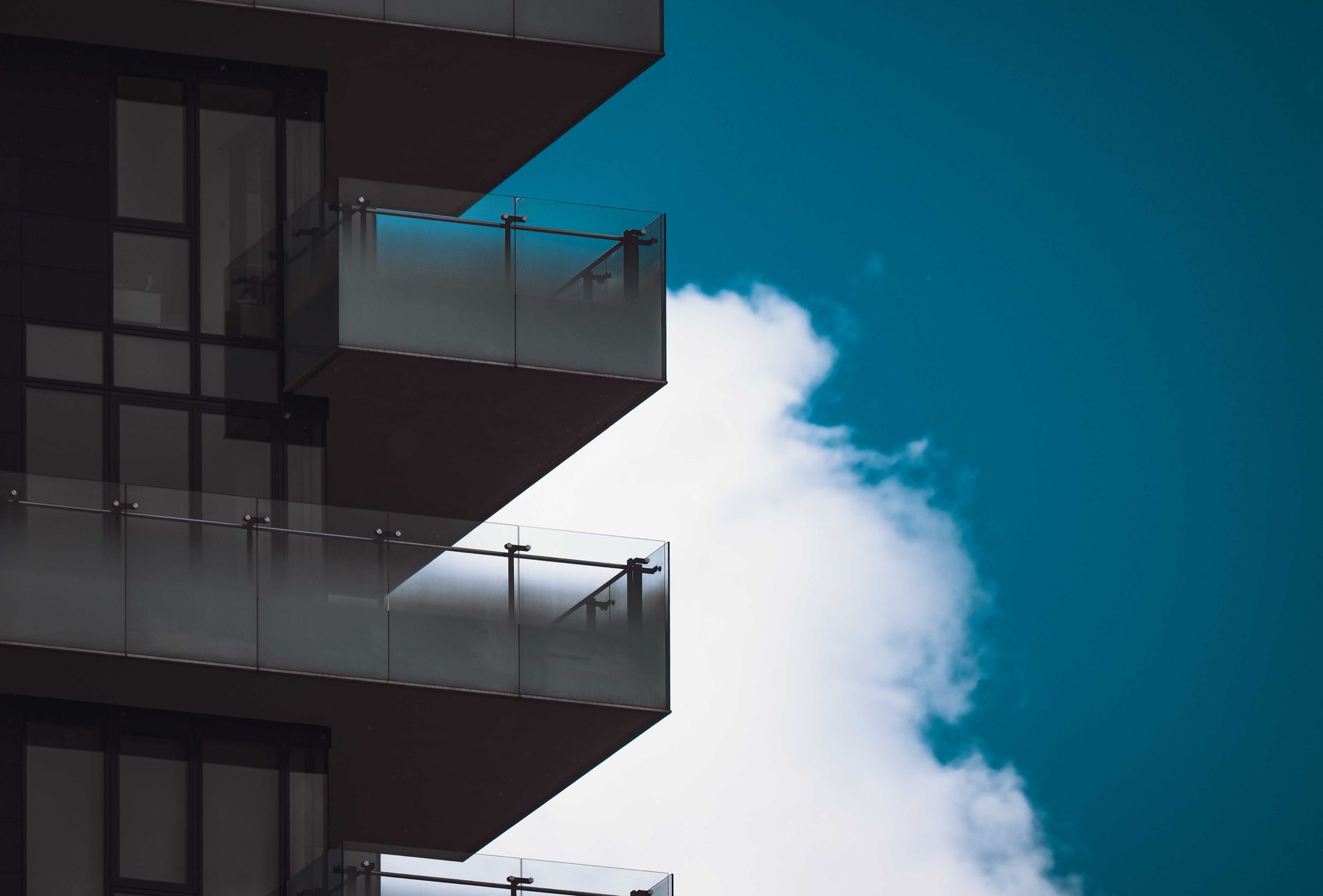 Frameless glass railing with minimal hardware on a modern residential balcony