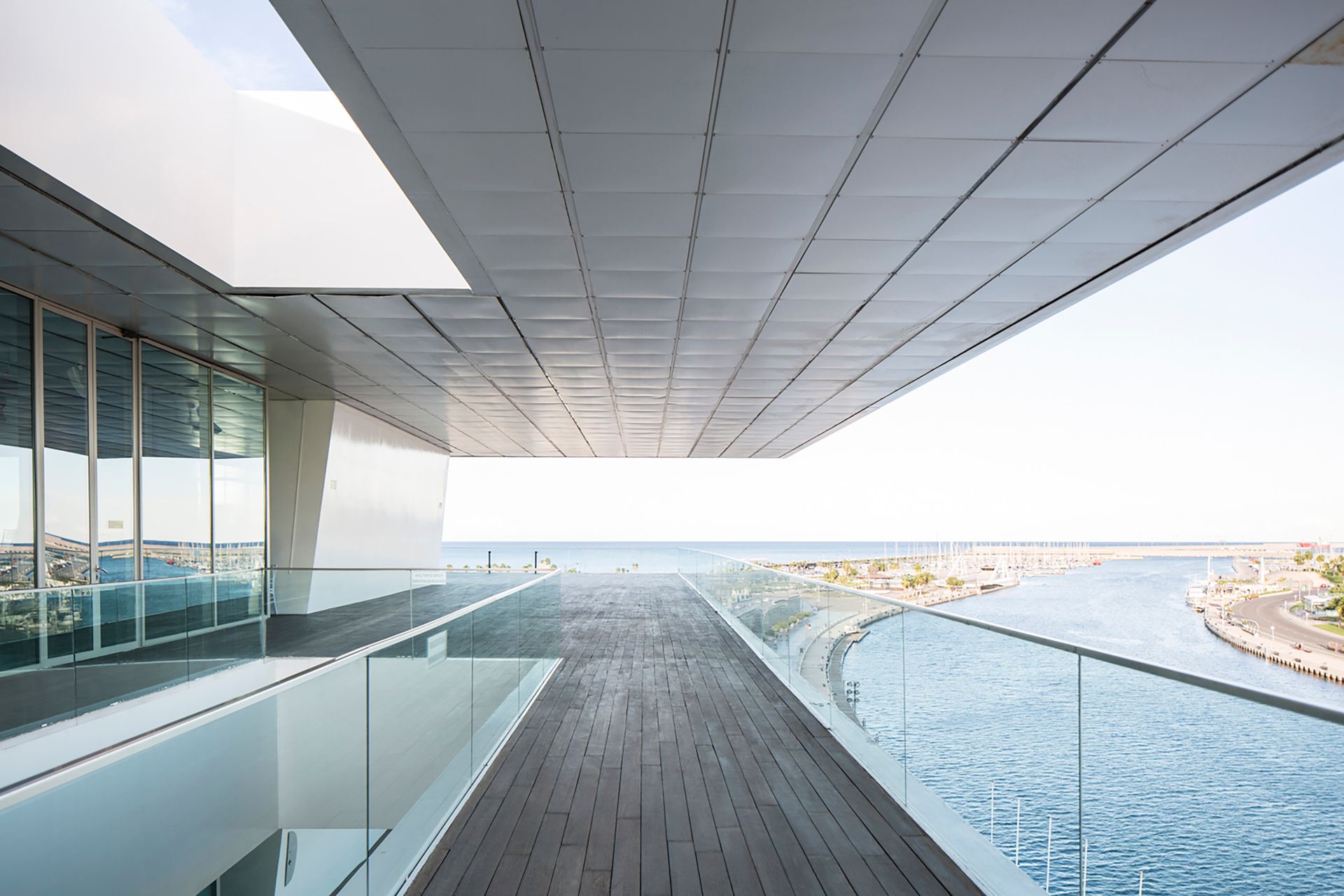 Clear glass railing on a residential balcony overlooking a coastal landscape